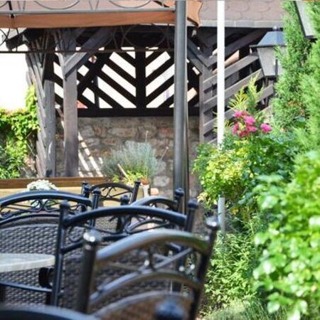 Der Sommergarten vom Weinhaus Becker, ausgestattet mit Pflanzen und Essgarnituren aus runden Tischen und Stühlen in Rattanoptik